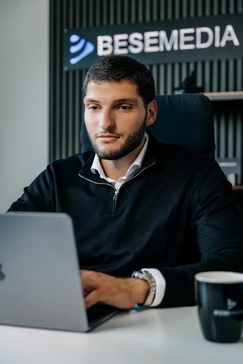Ein Bese-Media-Mitarbeiter arbeitet konzentriert am Laptop