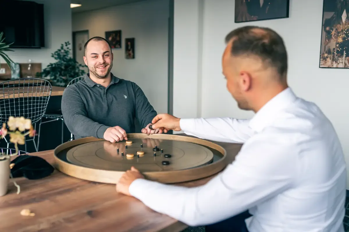 Zwei Bese-Media-Mitarbeiter beim Spiel am Holztisch in der Pause