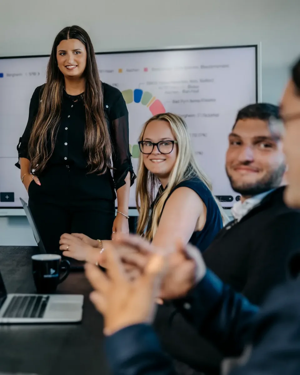 Mitarbeiter der Bese Media GmbH in einer Strategie-Besprechung vor dem Kampagnen-Dashboard