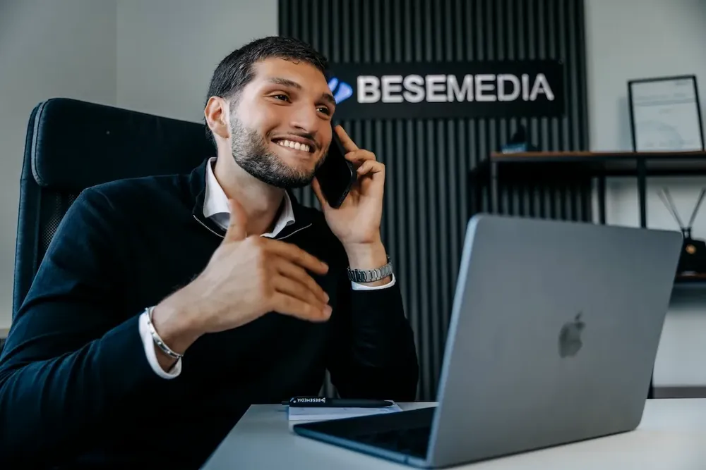 Ein Kollege von Bese Media telefoniert am MacBook
